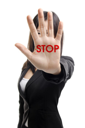 woman holding up hand with stop written on palm