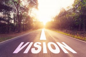 A road with the word "VISION" and an arrow pointing forward is surrounded by trees, leading to a bright, sunlit horizon, reminiscent of a journey guided by Robert's Rules.